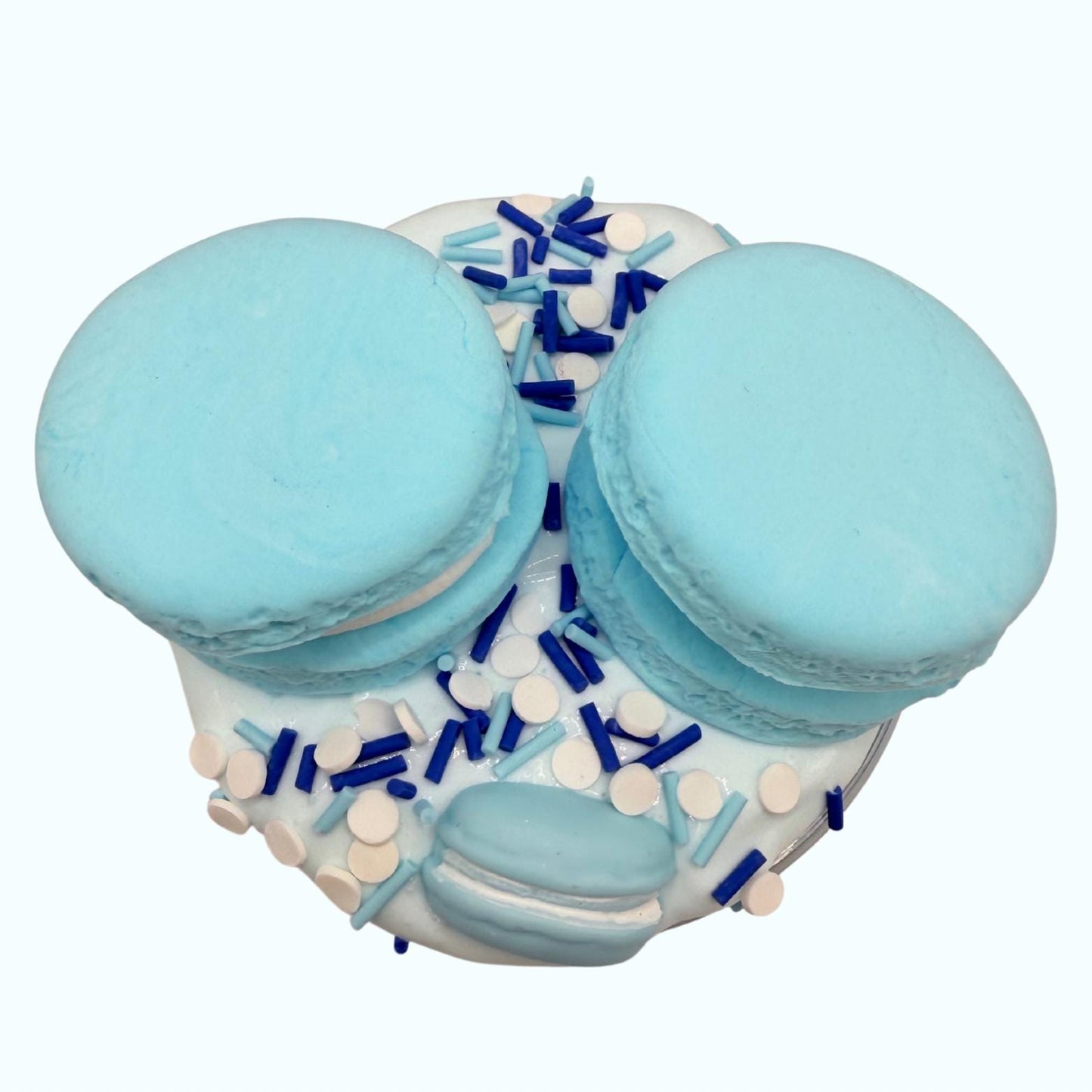Two blue macarons on a white surface with decorative elements.
