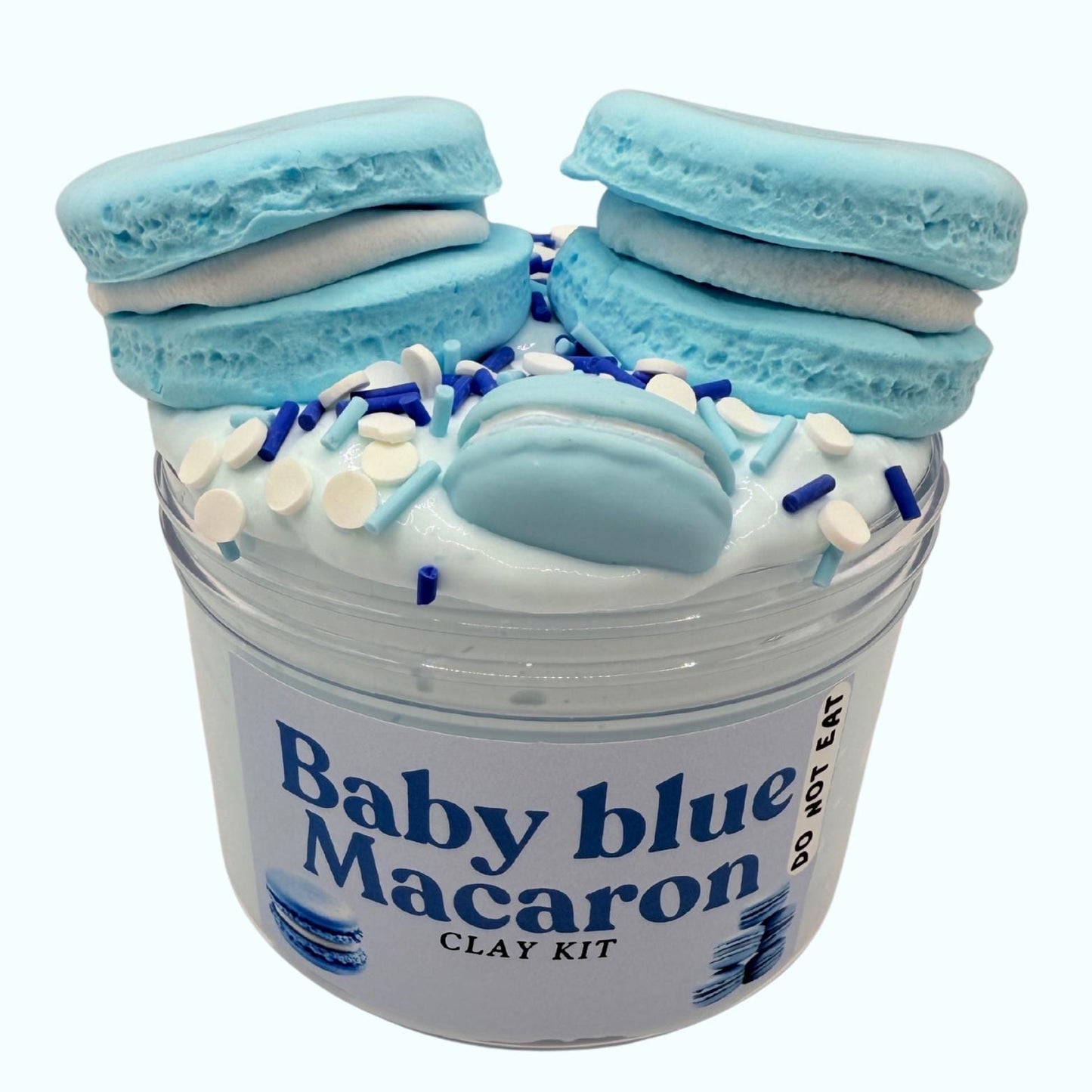 Baby blue macaron clay kit with white frosting and sprinkles in a clear container on a white background.